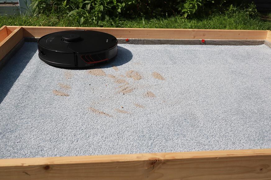 Roborock S7 MaxV убирает песок с ковра во время теста